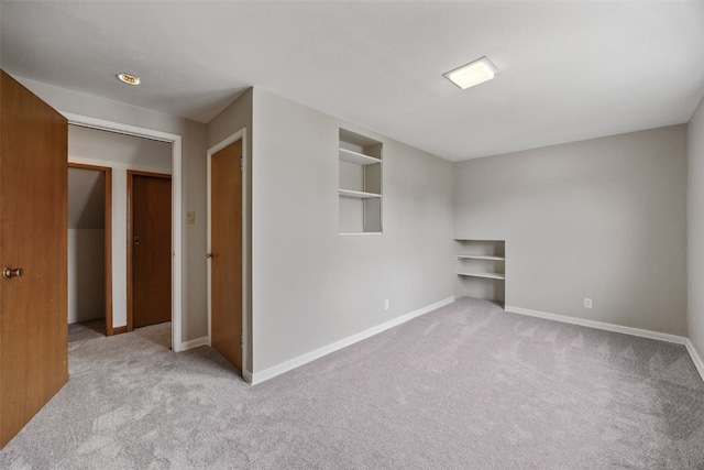 spare room featuring built in features, baseboards, and carpet flooring