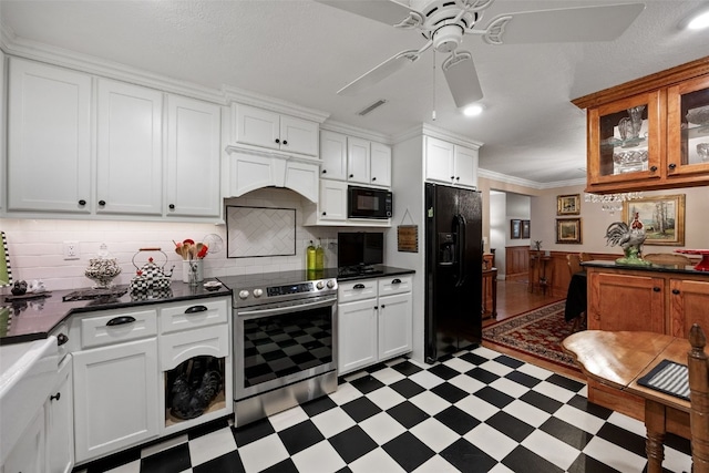 kitchen with dark countertops, light floors, a ceiling fan, and black appliances