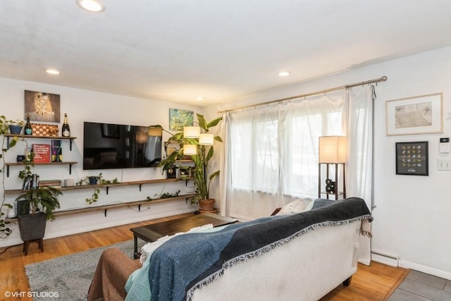 living area with recessed lighting and a baseboard heating unit