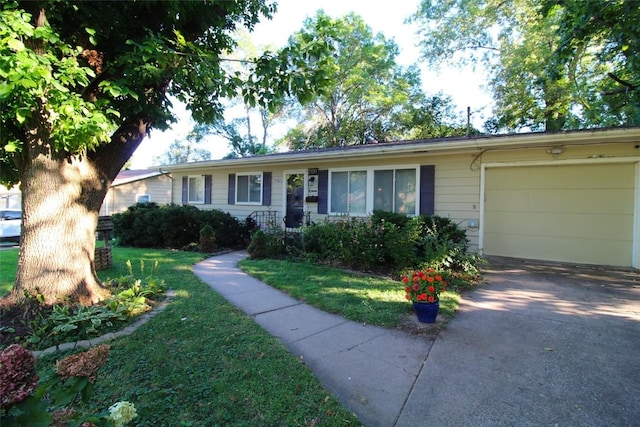 single story home with a garage, a front yard, and concrete driveway