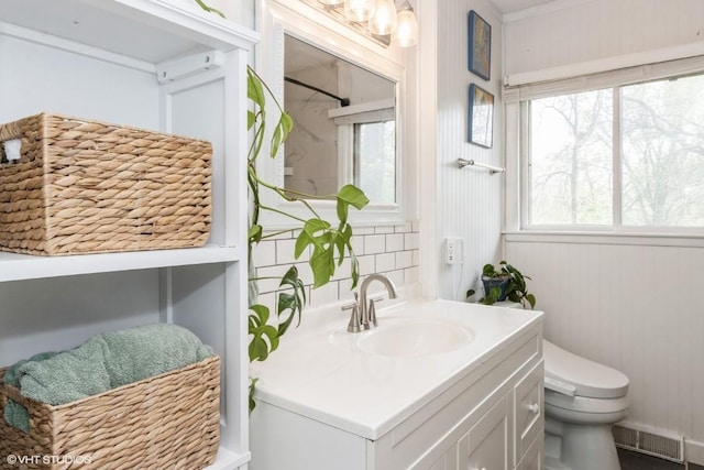 bathroom featuring vanity, toilet, a shower, and visible vents