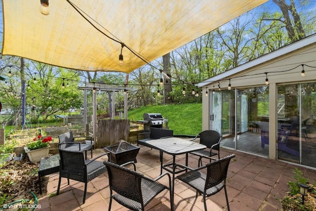 view of patio with fence, an outdoor living space with a fire pit, and grilling area