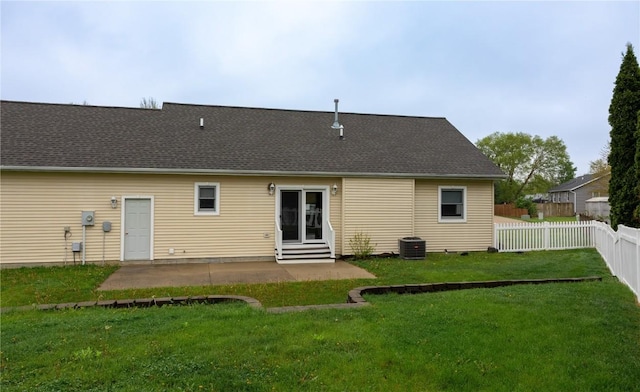 back of property featuring fence, entry steps, central AC unit, a patio, and a yard