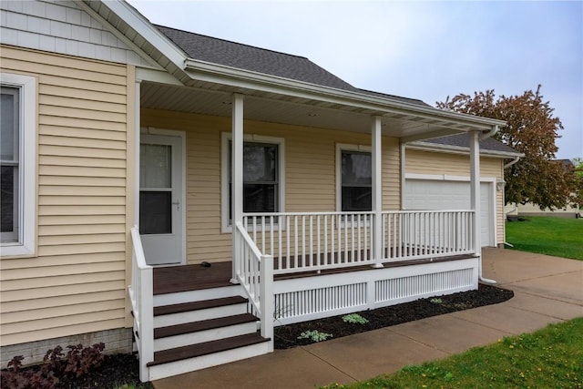 doorway to property featuring a garage, roof with shingles, covered porch, and driveway