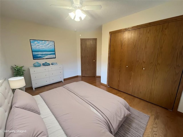bedroom featuring a ceiling fan, wood finished floors, and a closet