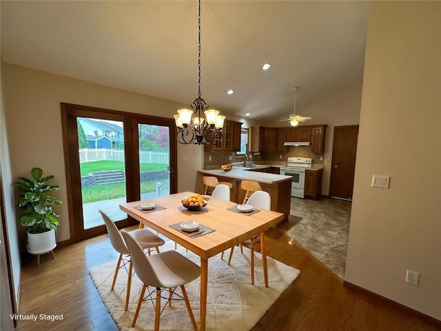dining room featuring recessed lighting, ceiling fan with notable chandelier, light wood finished floors, and lofted ceiling