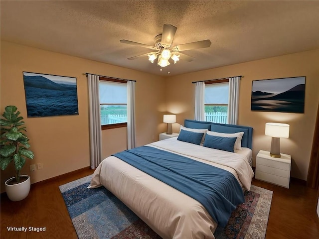 bedroom with a textured ceiling, ceiling fan, baseboards, and wood finished floors