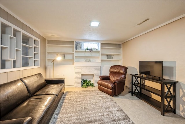 living room with a brick fireplace, ornamental molding, built in shelves, and carpet