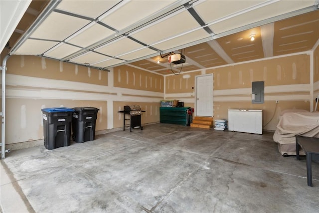 garage with a garage door opener and electric panel