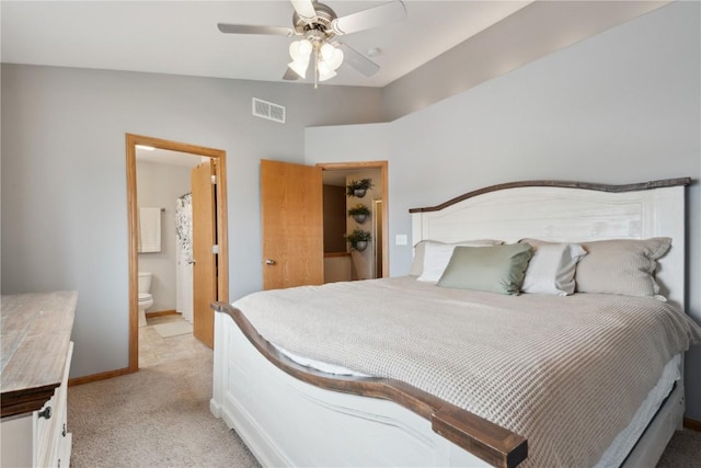 bedroom featuring ceiling fan, light carpet, ensuite bath, baseboards, and visible vents