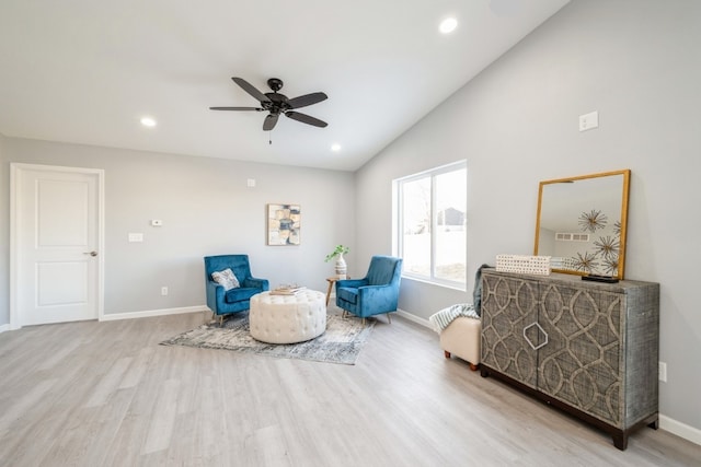 living area featuring baseboards, ceiling fan, vaulted ceiling, and wood finished floors