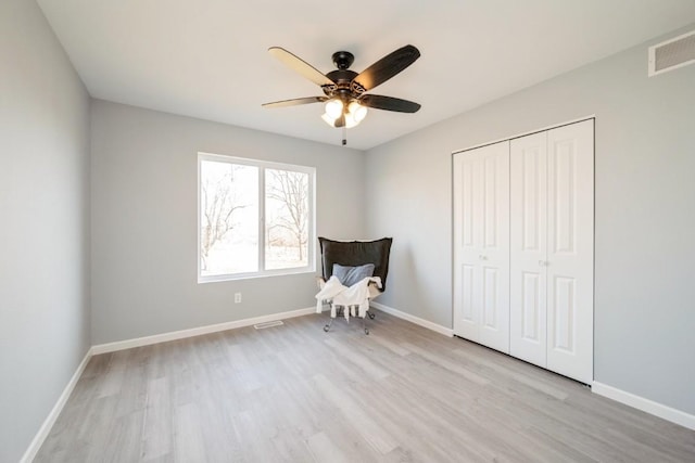 unfurnished room with ceiling fan, visible vents, baseboards, and light wood-type flooring
