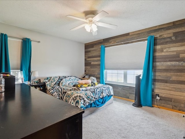 bedroom featuring a textured ceiling, carpet, ceiling fan, and wooden walls