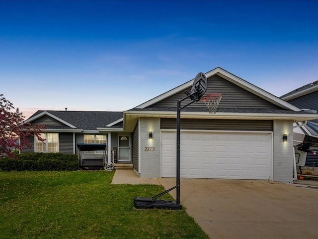 ranch-style home featuring a garage, concrete driveway, a front lawn, and brick siding