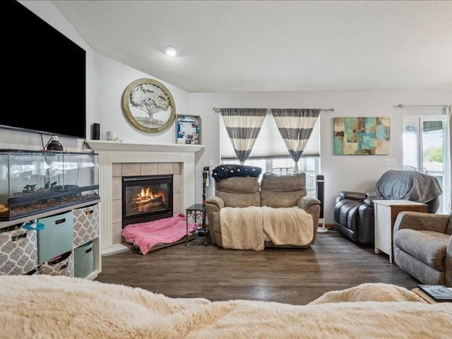 living area with wood finished floors and a tile fireplace
