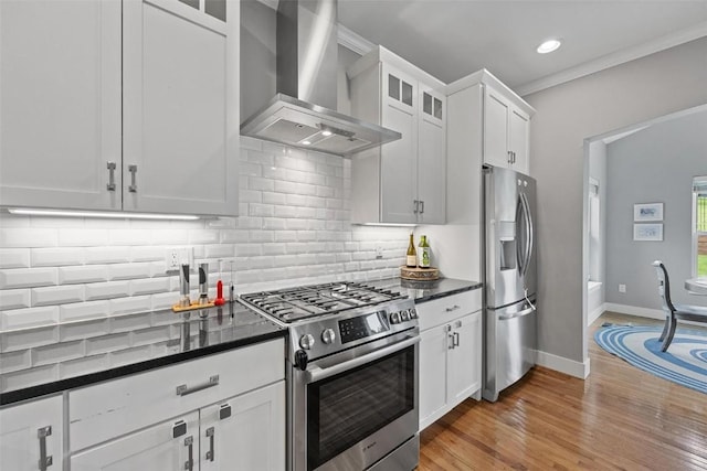 917 Robin Rd, Iowa City, IA 52246 - kitchen with glass insert cabinets, white cabinetry, decorative backsplash, wall chimney exhaust hood, and appliances with stainless steel finishes