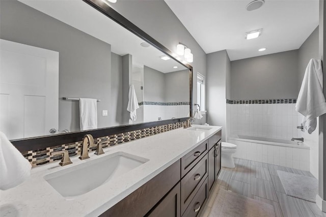 917 Robin Rd, Iowa City, IA 52246 - full bath featuring a sink, double vanity, toilet, and tiled bath