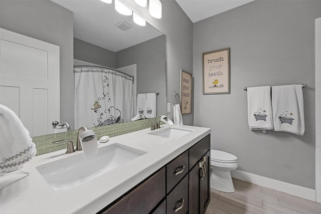 917 Robin Rd, Iowa City, IA 52246 - full bath featuring a sink, toilet, visible vents, and wood finished floors