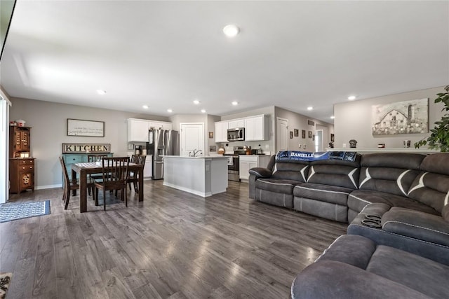 living room featuring baseboards, dark wood finished floors, and recessed lighting