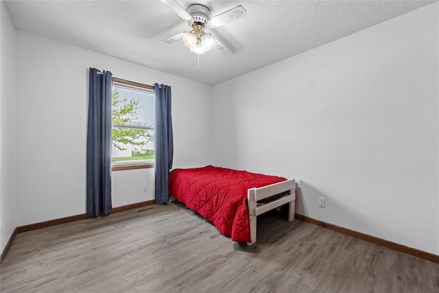 3325 29th Ave, Marion, IA 52302 - bedroom with baseboards, a textured ceiling, and wood finished floors