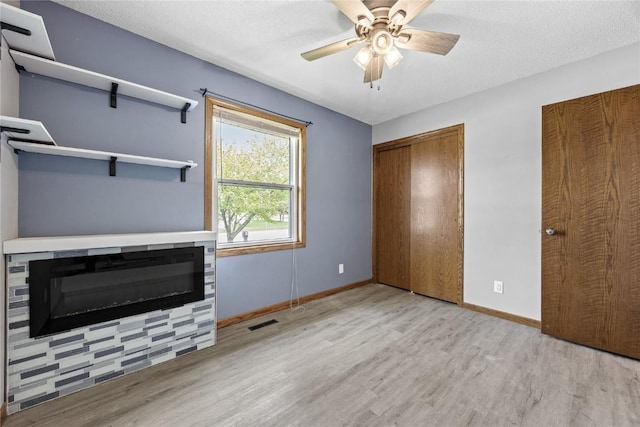 3325 29th Ave, Marion, IA 52302 - unfurnished bedroom with visible vents, wood finished floors, baseboards, and a glass covered fireplace
