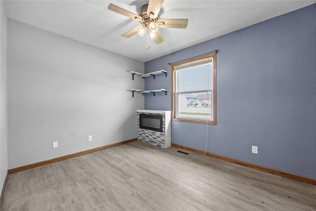 3325 29th Ave, Marion, IA 52302 - unfurnished room with a textured ceiling, baseboards, wood finished floors, and a ceiling fan
