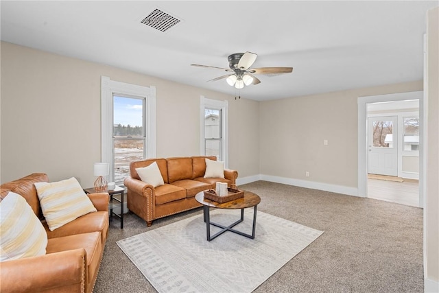 living room featuring ceiling fan, carpet flooring, visible vents, and plenty of natural light