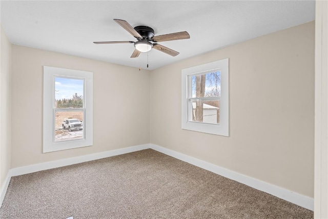 spare room with ceiling fan, carpet floors, and baseboards