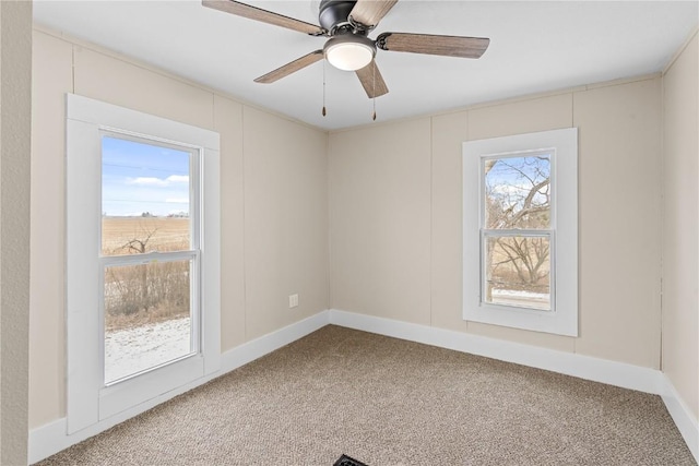 spare room with baseboards, a ceiling fan, and carpet floors