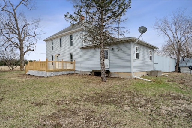 back of property featuring a lawn, a deck, and entry steps
