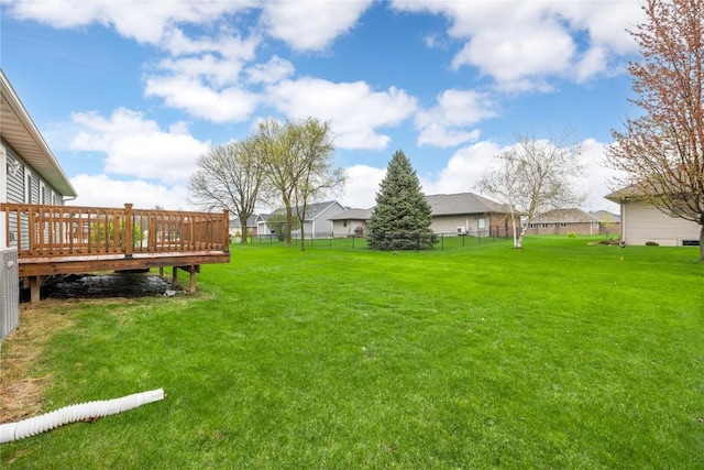 view of yard featuring a wooden deck, a residential view, and fence