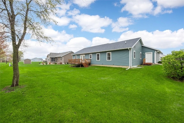 rear view of property featuring a yard and a wooden deck