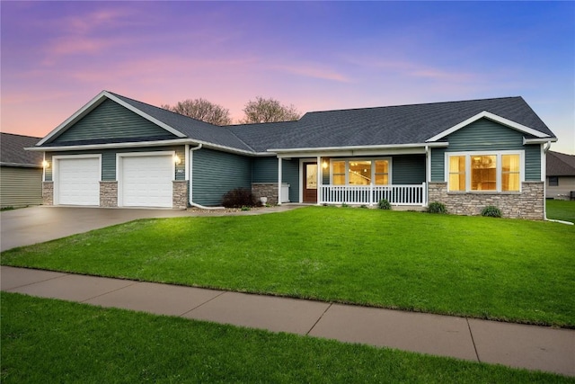 ranch-style home with covered porch, stone siding, concrete driveway, a garage, and a front lawn