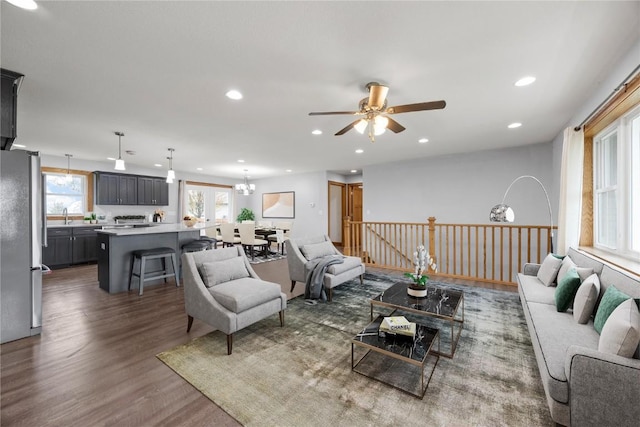 living area featuring recessed lighting, ceiling fan with notable chandelier, and wood finished floors