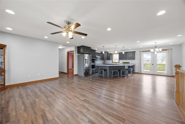 living room with baseboards, a healthy amount of sunlight, and dark wood-style floors