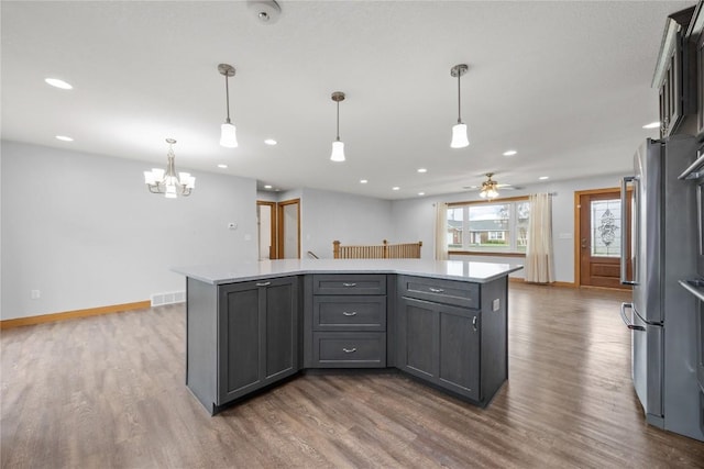 kitchen featuring a kitchen island, light countertops, and dark wood finished floors