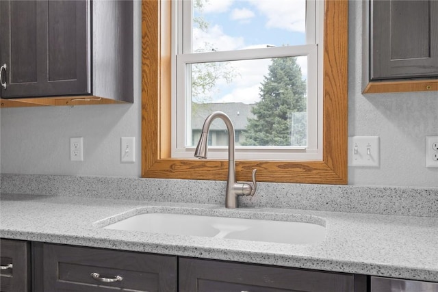 room details with a sink, a textured wall, and light stone counters