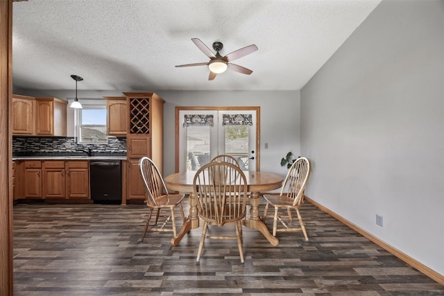 dining space with a textured ceiling, dark wood-type flooring, baseboards, and ceiling fan