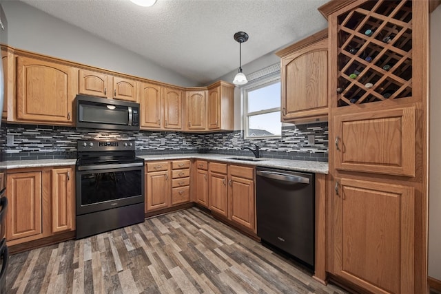 kitchen featuring a sink, electric range, a textured ceiling, stainless steel dishwasher, and lofted ceiling