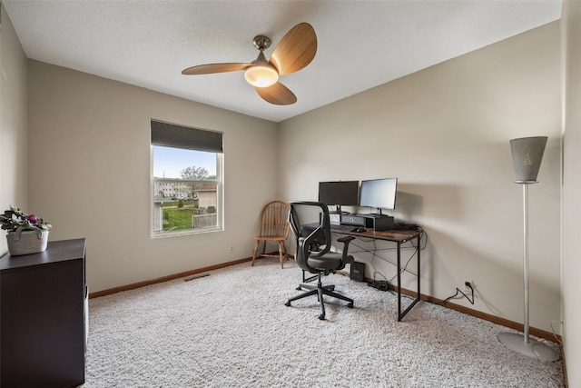 carpeted office featuring baseboards and ceiling fan
