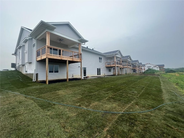 back of house featuring a yard, a balcony, and ceiling fan
