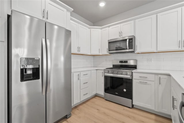 kitchen featuring stainless steel appliances, light countertops, light wood-type flooring, and white cabinets