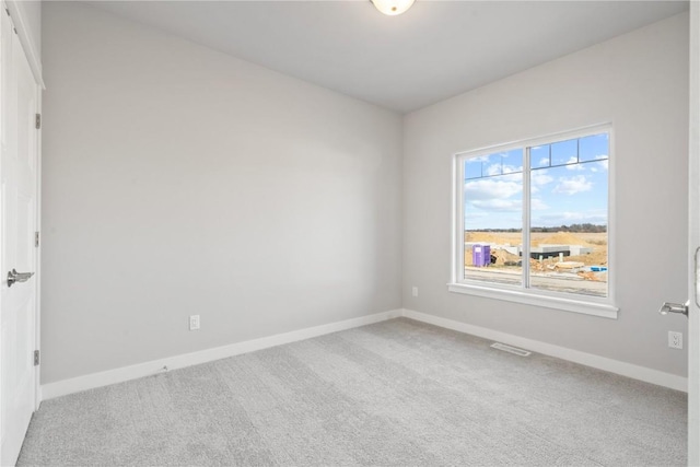 carpeted empty room featuring visible vents and baseboards
