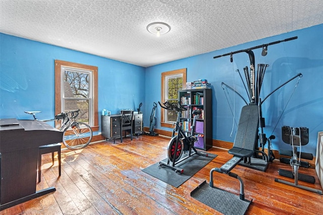 workout room with baseboards and hardwood / wood-style flooring