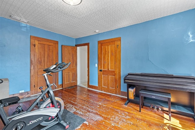 workout area featuring hardwood / wood-style floors and an ornate ceiling