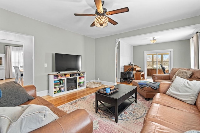 133 N 5th St, West Branch, IA 52358 - living area featuring a ceiling fan, light wood-style flooring, and baseboards