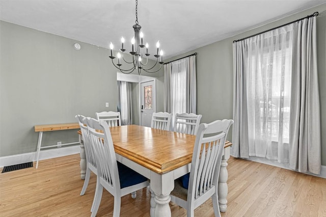 133 N 5th St, West Branch, IA 52358 - dining space featuring a chandelier, light wood-type flooring, and baseboards