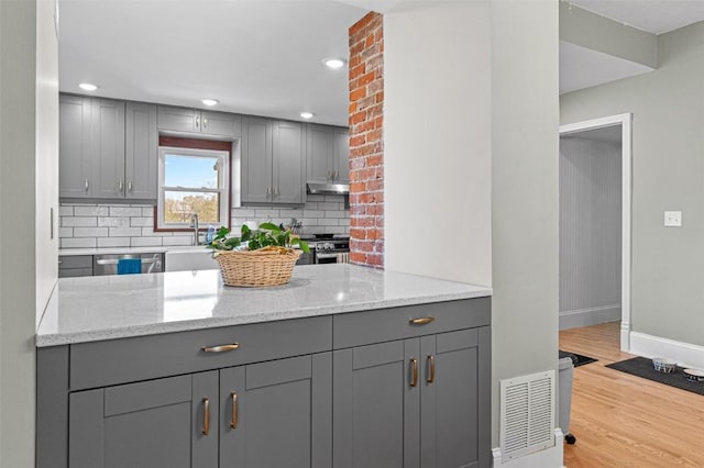 kitchen with gray cabinets, baseboards, visible vents, and backsplash