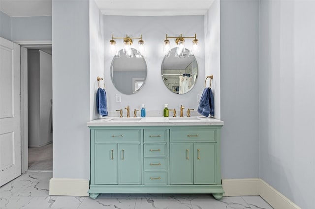 full bathroom with baseboards, marble finish floor, double vanity, and a sink