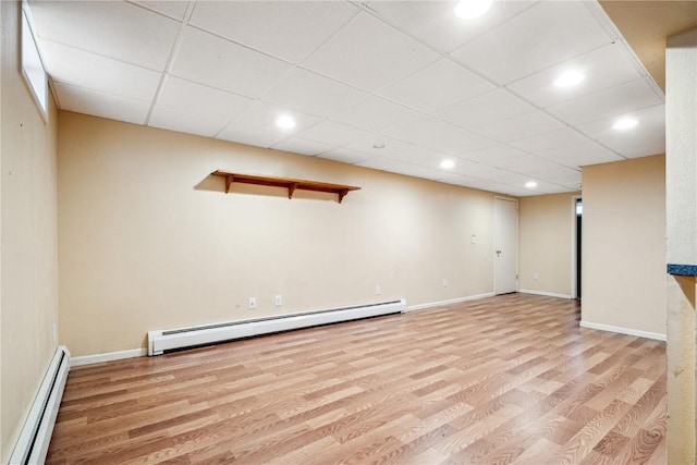 finished below grade area with baseboards, wood finished floors, baseboard heating, and recessed lighting